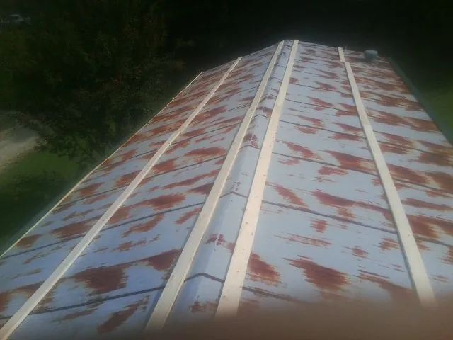 Rusted metal roof panels with new wood purlins before replacement — Storm Damage Roof Repair in Harrells by Roofing Brothers