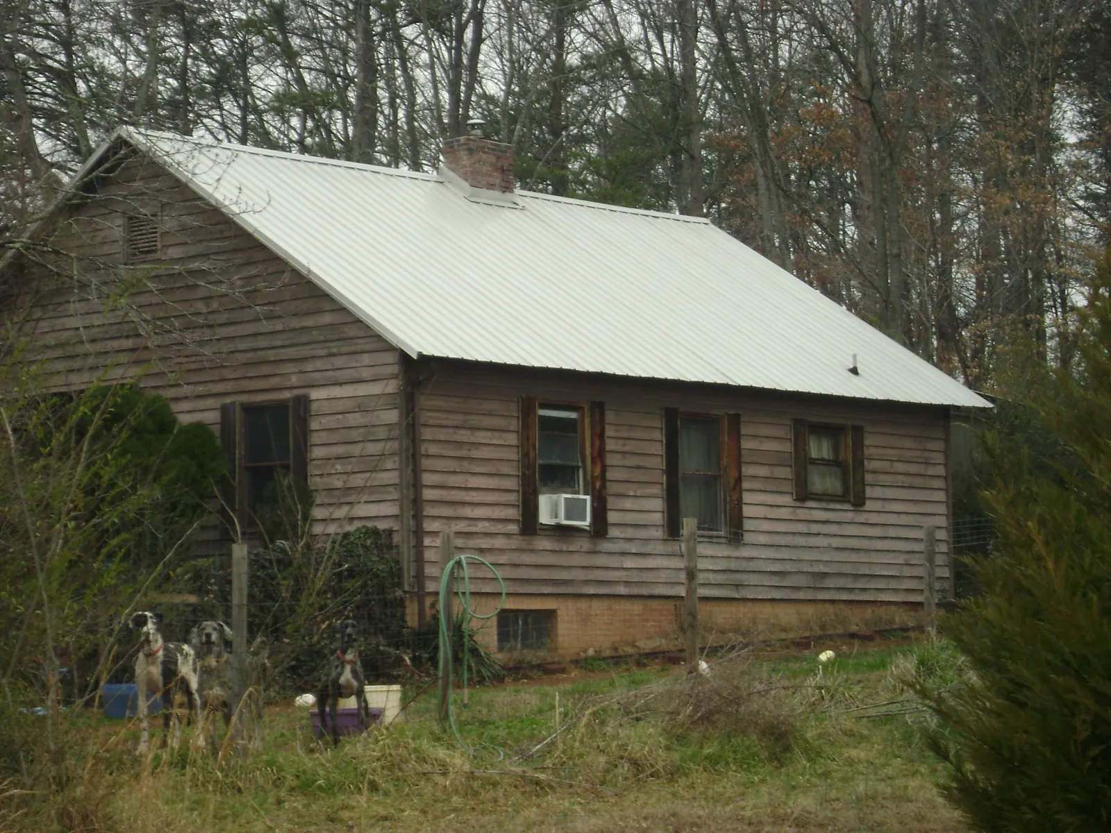White metal roof on an old wood sided farmhouse, from a Metal Roof Installation job in Harrells